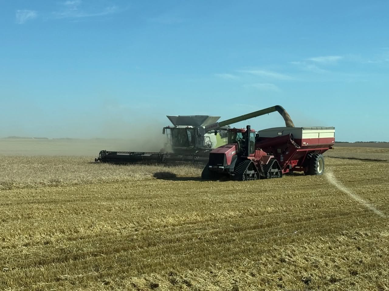 Combine unloading into a grain cart on a southwest Saskatchewan field